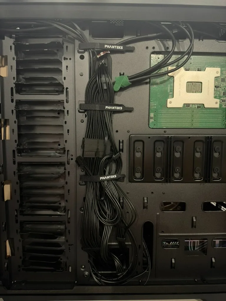 Close-up of the cable routing past the CPU cutout and drive mounts.