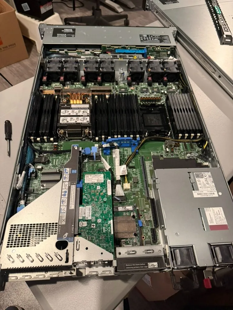 Lid off: fan wall, one CPU installed with the second socket open, and the PCIe riser.