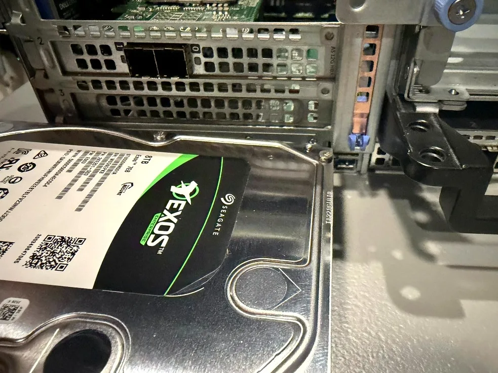 Seagate Exos 8TB SAS drive alongside the drive backplane.