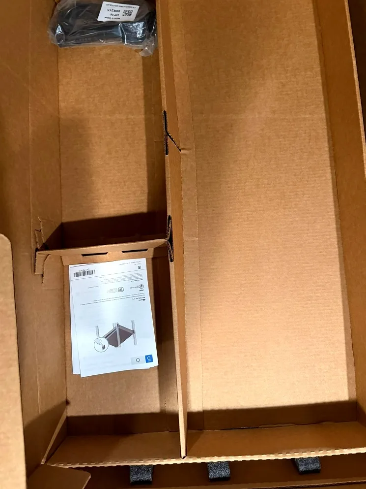 Accessory carton with power cord and setup documentation.